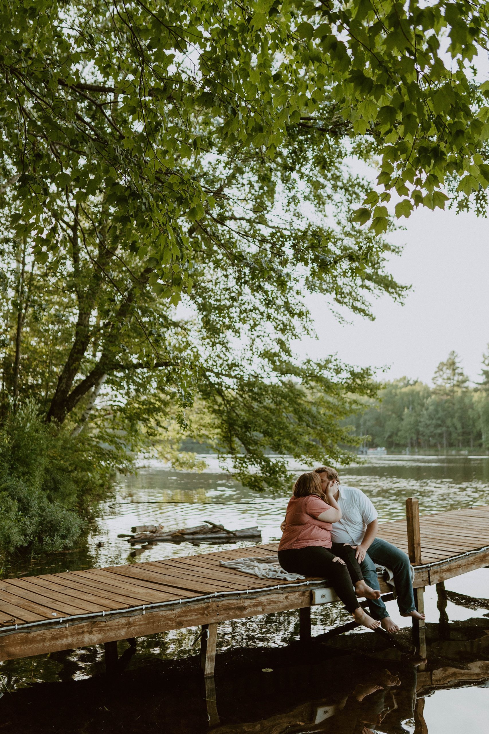 couple sitting on dock in northwoods