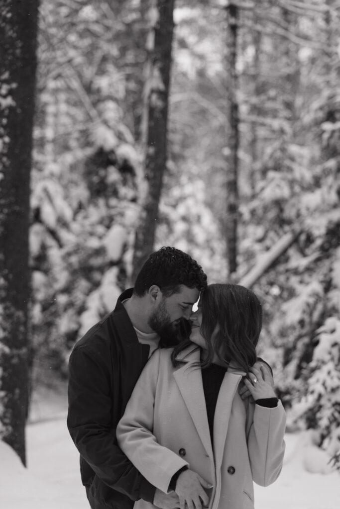 Black and white photo of a couple embracing during a winter engagement session in Northern Wisconsin